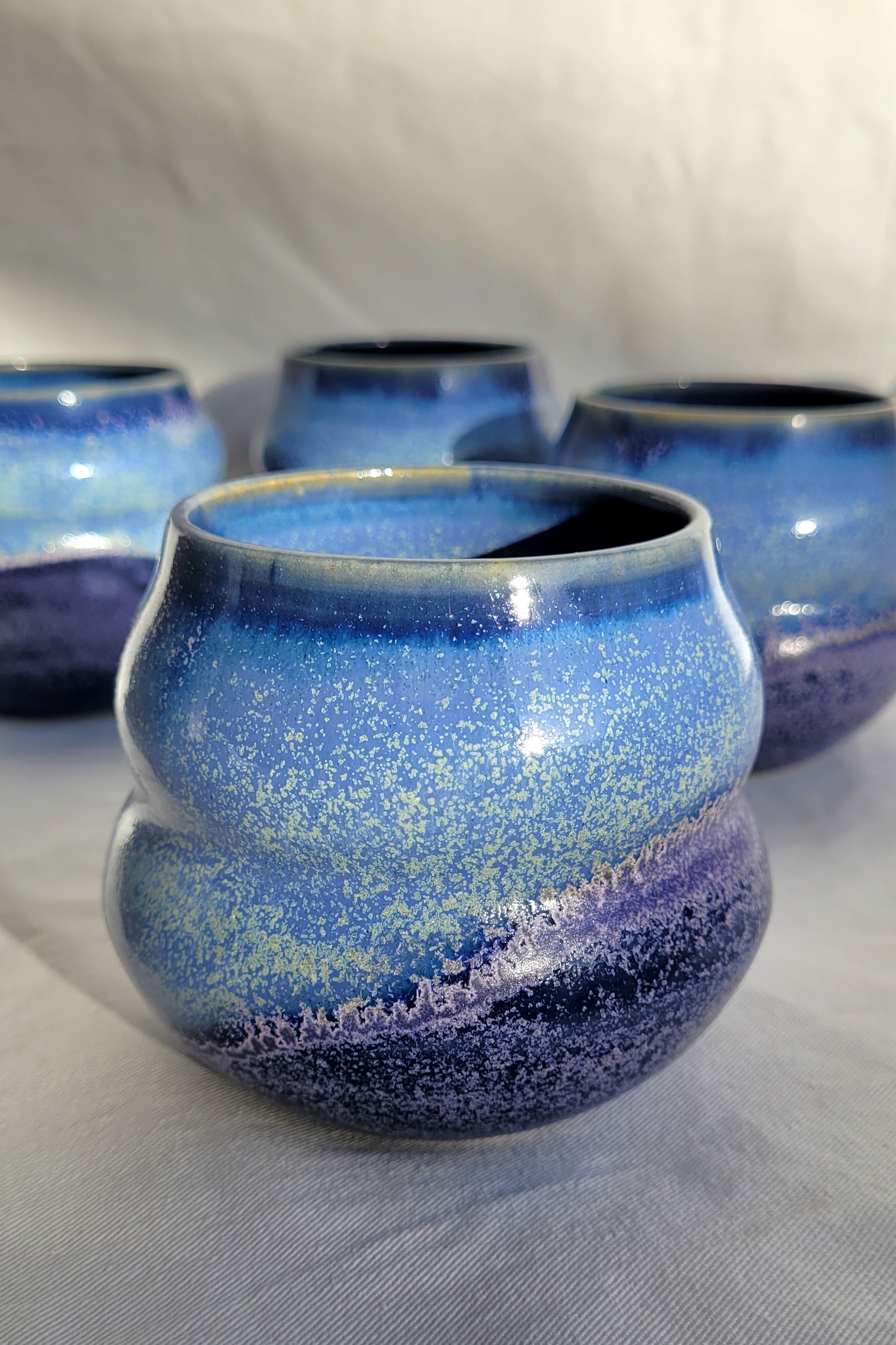 Wellenbecher mit sanfter Taille in der Mitte, oben glänzend, unten matt.