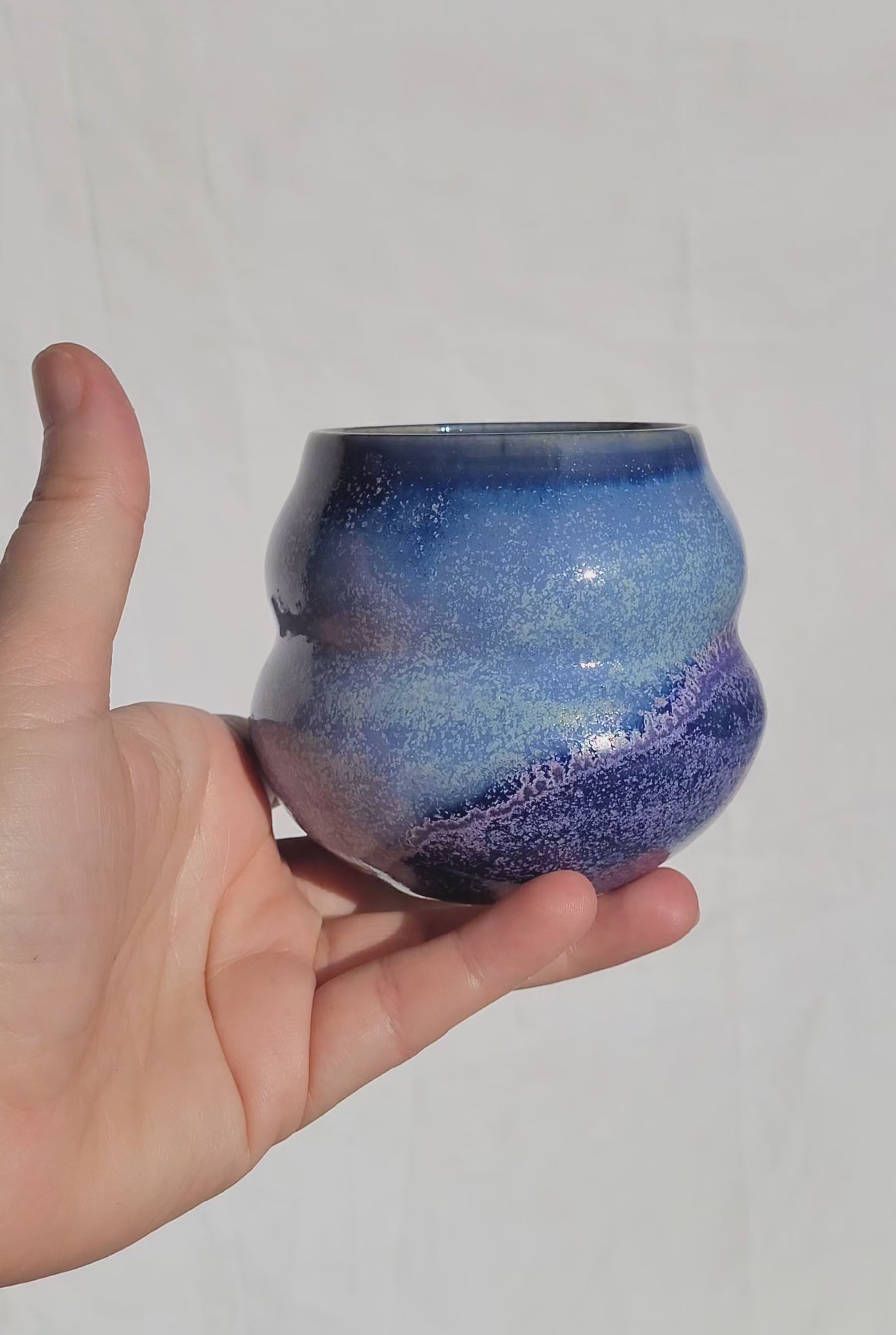 Wellenbecher mit sanfter Taille in der Mitte, oben glänzend, unten matt.